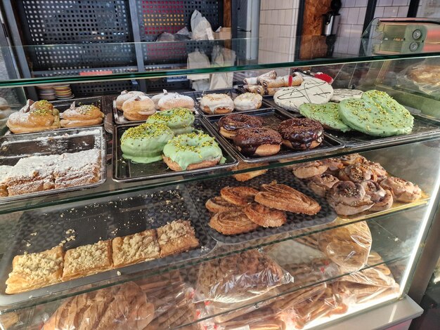 a variety of delicious pastries and baked goods are displayed on trays inside a glass counter