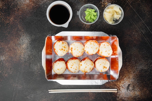 Variety of different sushi and rolls fro salmon and tuna in delivery food concept on old dark rustic background top view flat lay with copyspace and space for text