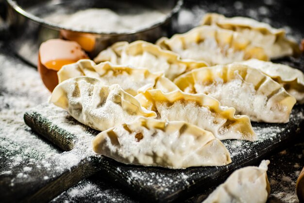 A variety of dumplings are on a table with flour on them.