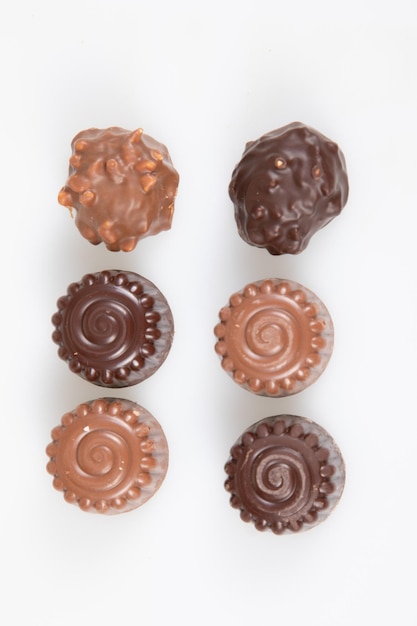 Variety fine artisanal chocolate pralines milk dark round candy on white background