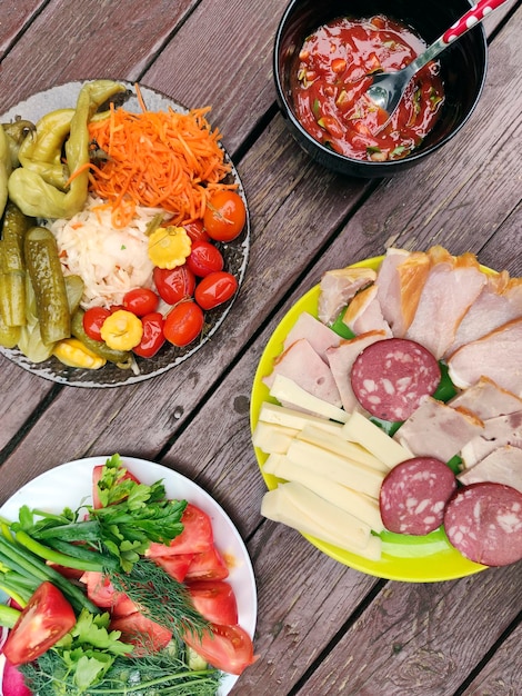 A variety of food in plates on a wooden table.