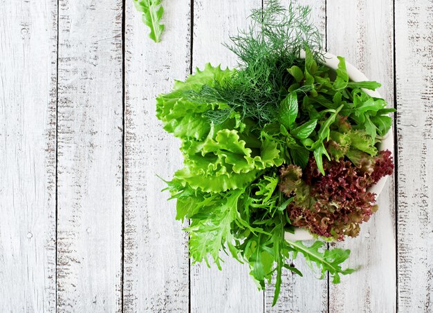 Variety fresh organic herbs on wooden surface in rustic style