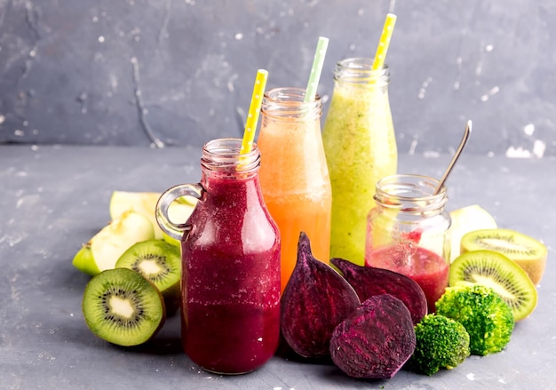 Variety of fresh vegetable and fruits moothie in glass bottles