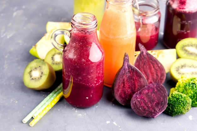 Variety of fresh vegetable and fruits moothie in glass bottles