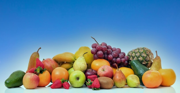 Variety of fruits stacked on blue color background