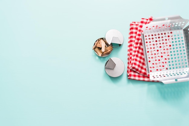 Variety of grilling tools on blue background.