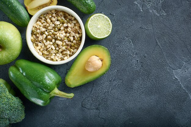 Photo a variety of healthy fresh raw foods vegetables and fruits are laid out on the stone surface