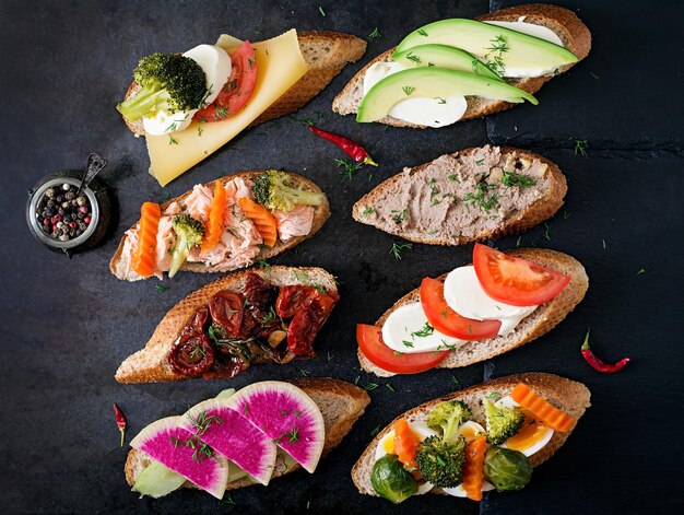 Variety of healthy sandwiches on a dark background in a rustic style Top view