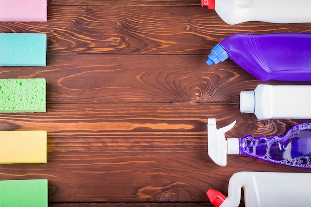 Variety house cleaning product on wood table with copy space, top view