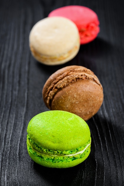 Variety of macarons on wooden background