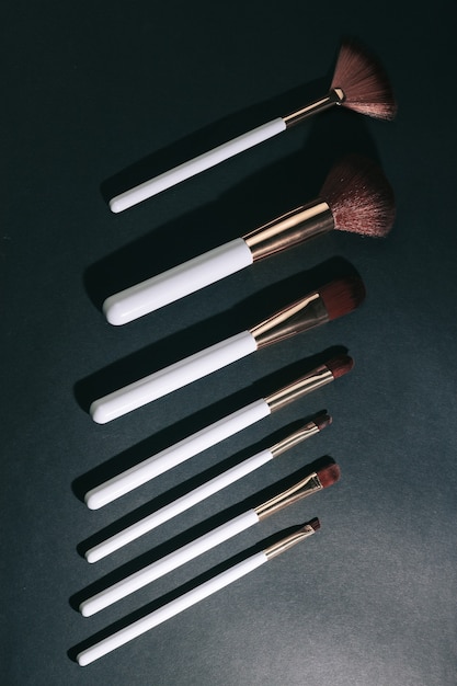 Variety of makeup brushes on a black background.photo with copy space