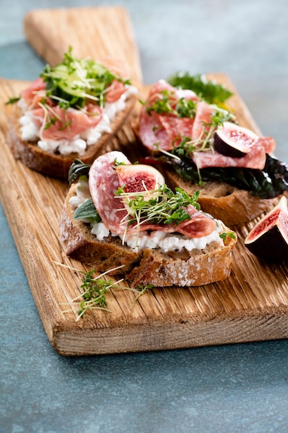 Variety of mini sandwiches with cream cheese vegetables and salami
