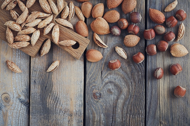 Variety of nuts: almonds, mountain almonds and hazelnuts on rustic wooden surface