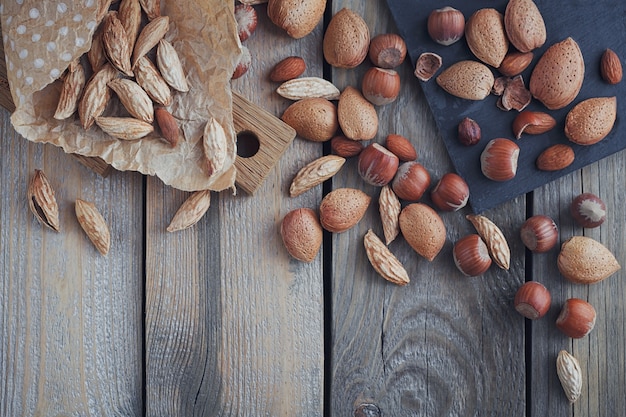 Variety of nuts: almonds, mountain almonds and hazelnuts on rustic wooden surface