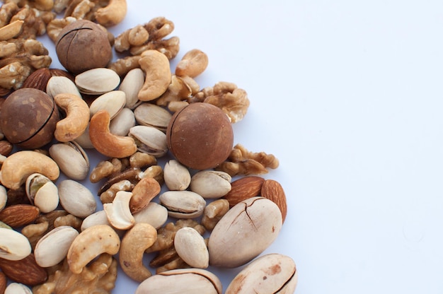 A variety of nuts scattered on a white background with space for text