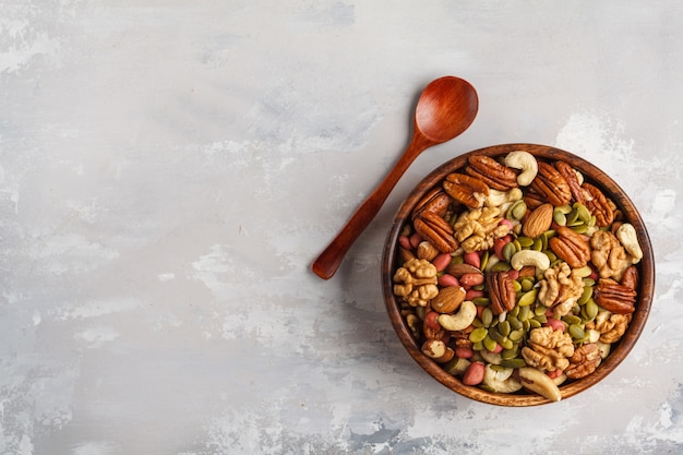 A variety of nuts and seeds in a wooden bowl, Food background, vegan healthy food concept. Copy space, top view.