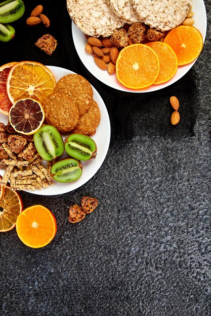 Variety of oat granola bars, rice crips, almond, kiwi and dried orange