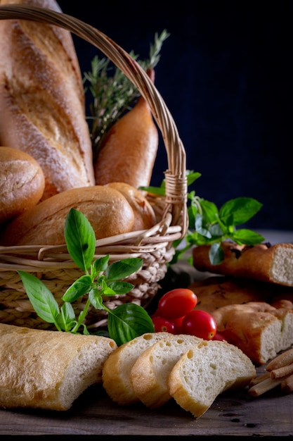 Фото Разнообразие хлеба в корзине на деревянном столе в темноте