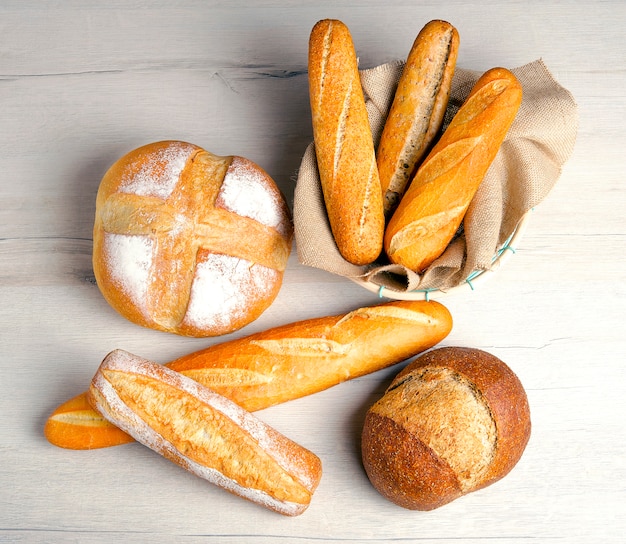 Фото Разнообразие хлебов на деревянном столе. вид сверху