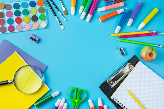 A variety of office supplies on a blue background back to school