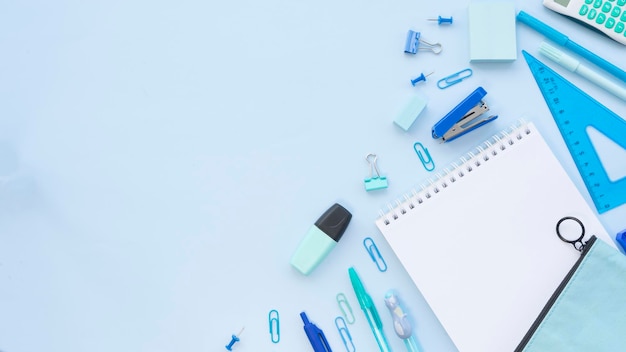 A variety of office supplies in blue color on a blue background