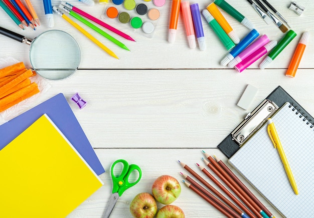 A variety of office supplies on a white wooden background top view copy space