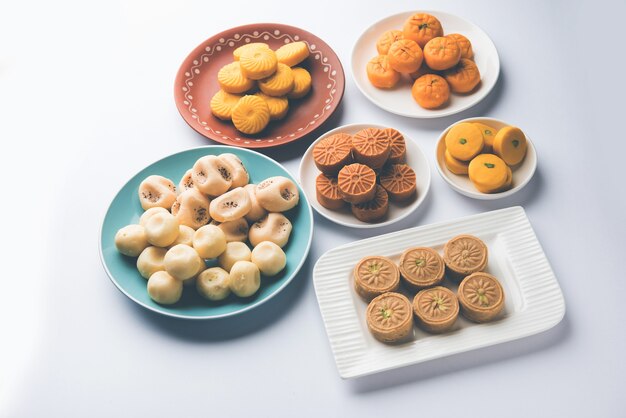 Variety of Peda or Pedha Served in a bowl or plate over white background or with pile of gifts. It's a popular festival food from India. selective focus