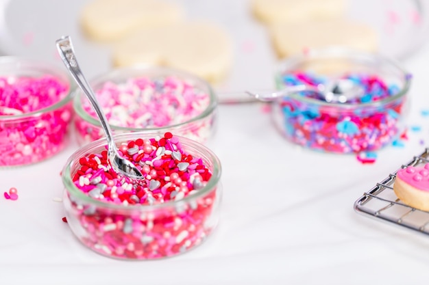 Variety of pink sprinkles for decorating Valentine's day cookies.