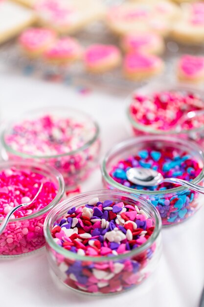Разнообразие розовой посыпки для украшения печенья ко дню святого Валентина.