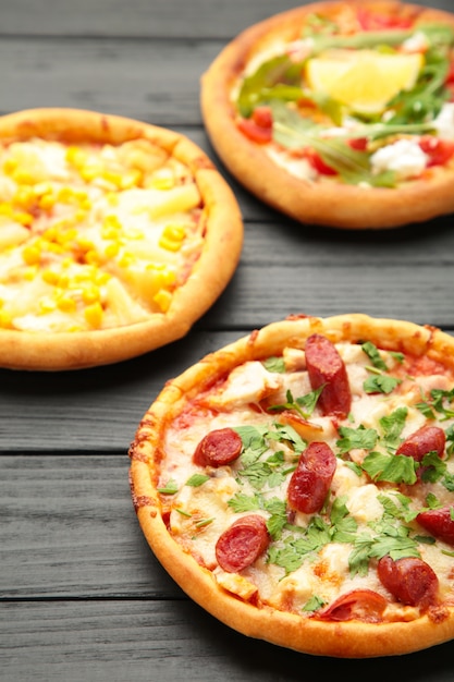 Variety of pizzas on a wooden table