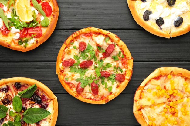 Variety of pizzas on a wooden table