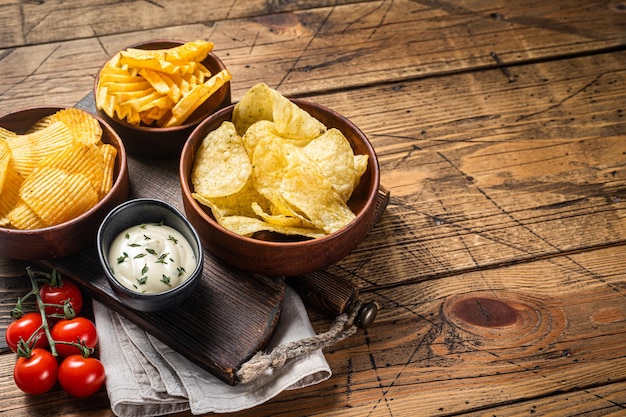 Variety of Potato chips Crinkle homemade hot BBQ Wooden background Top view Copy space