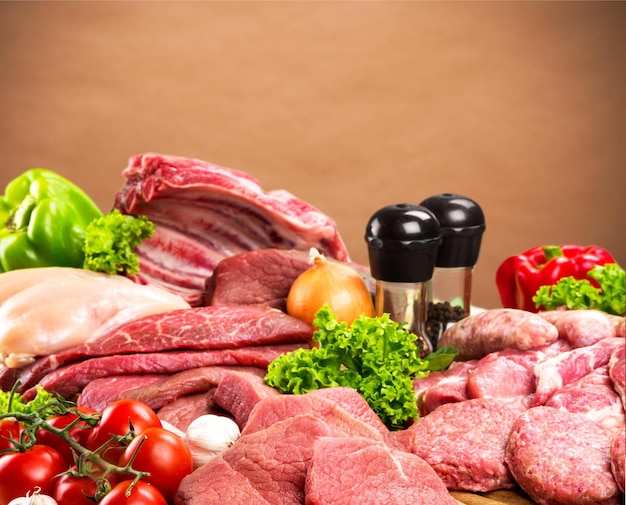 Variety of raw meat with spices on wooden table