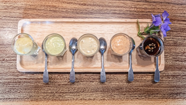 Foto varietà di condimento per l'insalata sulla tavola di legno