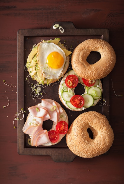 Variety of sandwiches on bagels with egg and vegetables