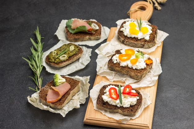 Variety of sandwiches for breakfast and appetizers on board and table.