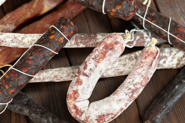 A variety of sausage products in closeup on a brown wooden background