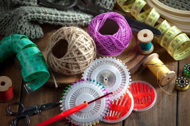 Различные швейные принадлежности, включая иглу, иголку, иголку, измерительную ленту и ножницы.