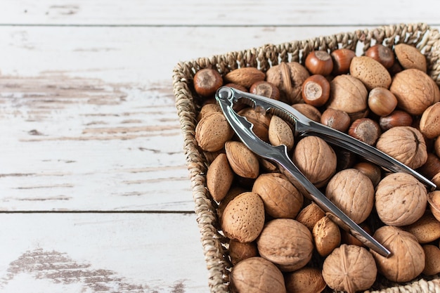 Variety of shelled nuts and nutcracker on wooden background