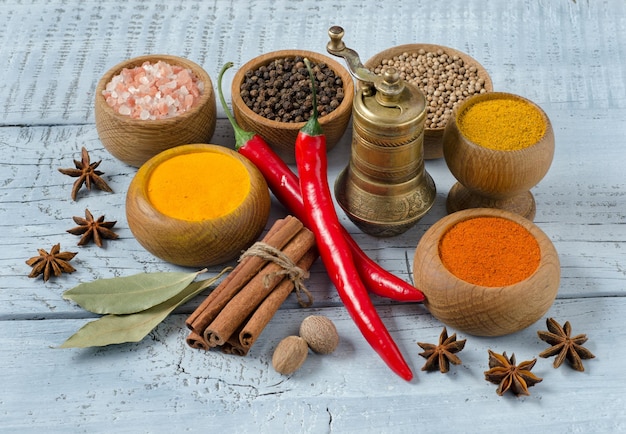 Variety of spice and seasonings for cookings for Indian cuisine on blue background.