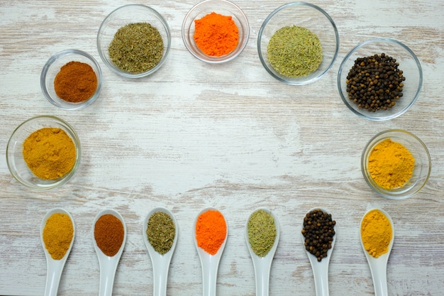 Photo variety of spices displayed in spoons and bowls