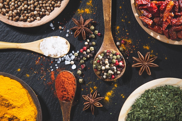 Photo variety of spices and herbs on black background