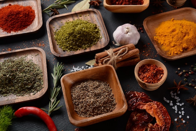 Variety of spices and herbs on kitchen table. Colorful various herbs and spices for cooking on dark background