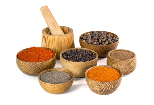 Variety of spices and seasonings in wooden bowl on white background