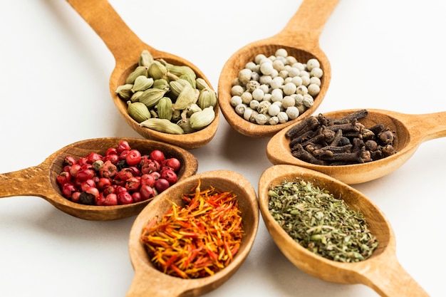 Photo variety of spices in wooden spoons