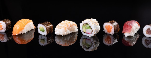 Variety of sushi isolated on black background. Traditional Japanese food.