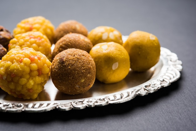 Variety of sweet laddu or laddoo in a silver plate, a sweet dumpling made up of bundi, dry fruits or rava, selective focus