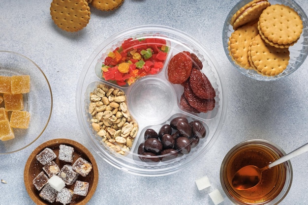 Photo a variety of sweets dried fruits nuts cookies and tea are on the bright table