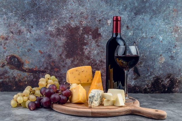 Foto varietà di gustosi formaggi e uva con vino