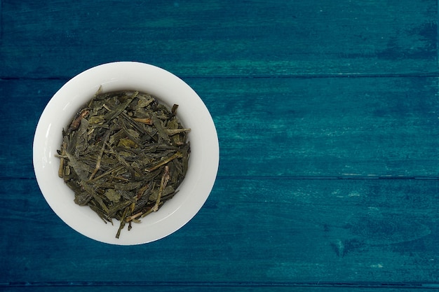 variety of tea in strands and coffee beans on rustic wooden background 